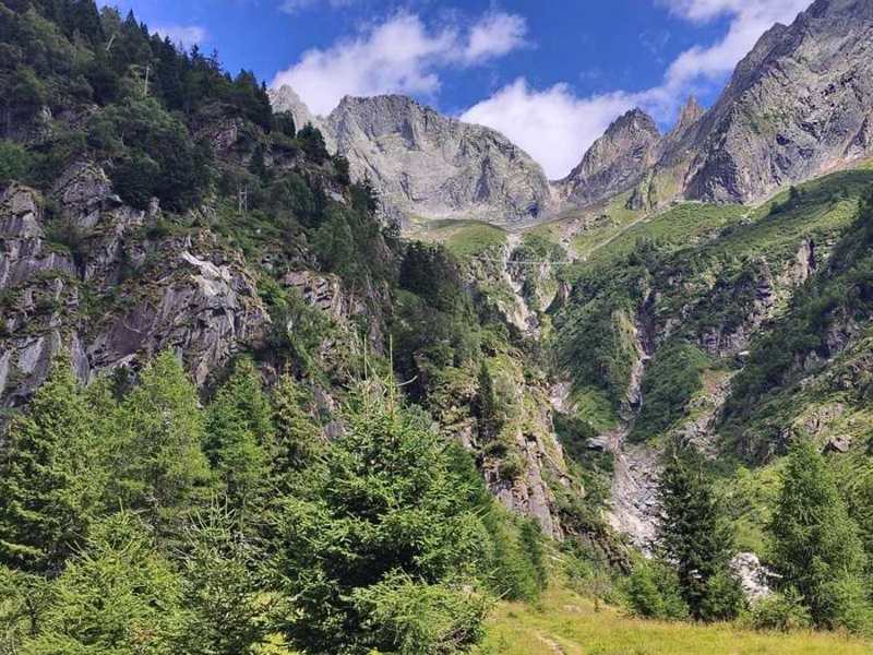 Pareti di roccia e, in alto, un ponte sospeso sul vallone