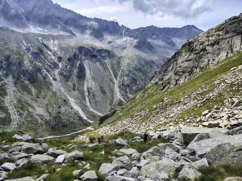 Salita tra i massi, con il torrente in fondo alla valle