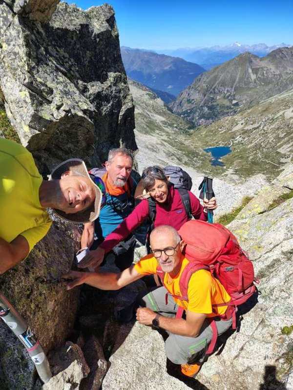 In quattro per una foto, con la valle e un lago sullo sfondo