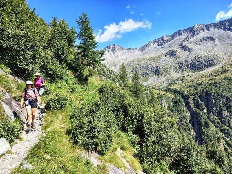 Il sentiero sopra la valle, con una cascata sullo sfondo
