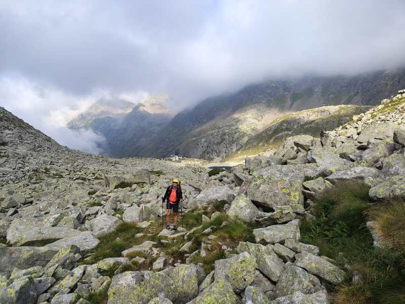 Si sale tra i massi, con il rifugio e il lago ormai in basso