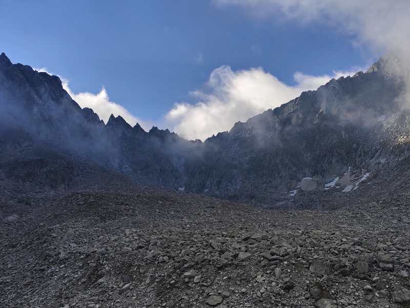 Il circo di pietre sotto le guglie, avvolto dalle nuvole