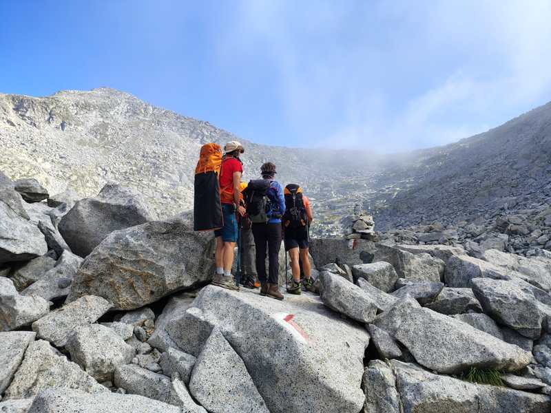Una sosta al segnavia, con l’ometto di pietre e la salita davanti
