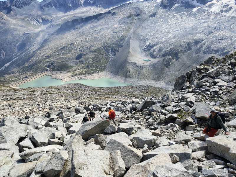 La discesa sul ghiaione, con la diga e due laghi in basso