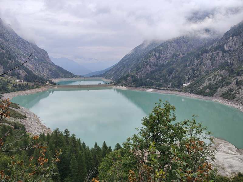 Il grande lago con la diga, avvolto dalle nuvole